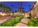 Serene backyard with a walkway, lush landscaping, and ambient lighting; a perfect outdoor retreat at 7521 Dry Pines Cir, Las Vegas, NV 89129