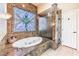 Luxurious bathroom features marble finishes, a soaking tub under a stained glass window and separate glass shower enclosure at 7521 Dry Pines Cir, Las Vegas, NV 89129