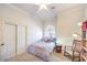 A lovely bedroom features a charming arched window, a rocking chair, and plenty of storage space at 7521 Dry Pines Cir, Las Vegas, NV 89129