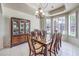 Elegant dining room with large windows, tile floors, and decorative chandelier at 7521 Dry Pines Cir, Las Vegas, NV 89129