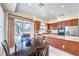 Kitchen area with wood cabinets, granite countertops, and dining table next to glass doors to outside at 7521 Dry Pines Cir, Las Vegas, NV 89129