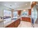 Modern kitchen with a large island, granite countertops, stainless steel appliances, and a dining area with backyard views at 7521 Dry Pines Cir, Las Vegas, NV 89129