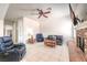Spacious living room with tile flooring, brick fireplace, ceiling fan and comfortable seating furniture at 7521 Dry Pines Cir, Las Vegas, NV 89129