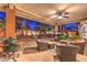 Inviting covered patio with outdoor seating, grill, and landscaped backyard with a tv for entertainment at 7521 Dry Pines Cir, Las Vegas, NV 89129