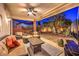 Cozy covered patio area with comfortable seating, a television, and beautifully landscaped surroundings for relaxation at 7521 Dry Pines Cir, Las Vegas, NV 89129
