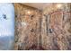 This shower boasts marble walls and two shower heads including one mounted to the wall and one handheld shower at 7521 Dry Pines Cir, Las Vegas, NV 89129