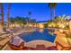 Sparkling pool and spa surrounded by lounge chairs, palm trees, and manicured landscaping; ideal for relaxation at 7521 Dry Pines Cir, Las Vegas, NV 89129