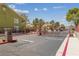 Gated community entrance with 'Resident' and 'Guest' lanes, mature trees, and colorful buildings at 7950 W Flamingo Rd # 2066, Las Vegas, NV 89147
