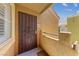 Tan condo exterior featuring an iron security gate over the front door, stairs and concrete porch at 7950 W Flamingo Rd # 2066, Las Vegas, NV 89147