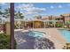Hot tub next to the pool with an outdoor lounge and umbrellas at 7950 W Flamingo Rd # 2066, Las Vegas, NV 89147