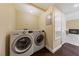 Bright laundry room featuring modern front-load washer and dryer on dark wood-look floors, with a utility closet at 7950 W Flamingo Rd # 2066, Las Vegas, NV 89147