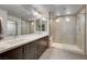 Modern main bathroom features a double vanity, sleek mirrors, and a glass-enclosed walk-in shower with seat at 8087 Carpenter Creek Ave, Las Vegas, NV 89113