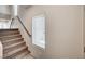 Carpeted staircase with wooden handrail, illuminated by a window, providing access to the upper levels at 8087 Carpenter Creek Ave, Las Vegas, NV 89113