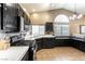 Bright kitchen features a stylish chandelier, stainless steel appliances, black cabinets, and sleek white countertops at 812 Rio Poco Ct, Henderson, NV 89015