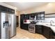 Well-equipped kitchen features stainless steel appliances, black cabinets, and easy access to the laundry room at 812 Rio Poco Ct, Henderson, NV 89015