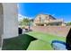 The home has a well-manicured backyard with green grass, patio, barbecue, and tall walls for privacy at 8212 Swallow Falls St, North Las Vegas, NV 89085