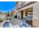 A well-maintained backyard with a covered patio, outdoor seating, barbecue grill, and lush green lawn at 8212 Swallow Falls St, North Las Vegas, NV 89085
