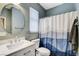 Bathroom with a sink and vanity, a toilet, and a shower-tub combo with mountain-themed curtain at 8212 Swallow Falls St, North Las Vegas, NV 89085