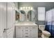 Bathroom features a double vanity with white cabinets, oval mirrors, and a shower-tub combo at 8212 Swallow Falls St, North Las Vegas, NV 89085