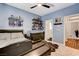 This bedroom with guitar on wall, carpet, shelving, and a bed with comfortable bedding at 8212 Swallow Falls St, North Las Vegas, NV 89085