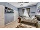 This bedroom features carpet, a bed with comfortable bedding, and a guitar on the wall at 8212 Swallow Falls St, North Las Vegas, NV 89085