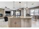 Kitchen island features stainless steel dishwasher and sink, with living room fireplace in the background at 8212 Swallow Falls St, North Las Vegas, NV 89085