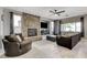 Bright living room with a stone fireplace, comfortable seating, and large windows for plenty of natural light at 8212 Swallow Falls St, North Las Vegas, NV 89085