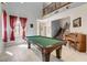 Open-concept living space with a game table, piano, and staircase at 8212 Swallow Falls St, North Las Vegas, NV 89085