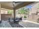 A covered outdoor patio featuring a ceiling fan and comfortable seating area with patterned pillows and area rug at 8212 Swallow Falls St, North Las Vegas, NV 89085