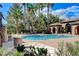 Community pool with palm trees, lounge chairs, and manicured landscaping for a resort-like experience at 8212 Swallow Falls St, North Las Vegas, NV 89085