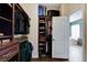 Organized walk-in closet featuring dark wood shelving and storage for clothing and accessories at 8212 Swallow Falls St, North Las Vegas, NV 89085