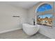 This soaking tub is surrounded with marble and is located next to a window at 8232 Ocean Terrace Way, Las Vegas, NV 89128