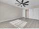 Bright bedroom with gray wood floors, closet, and modern ceiling fan at 8232 Ocean Terrace Way, Las Vegas, NV 89128