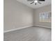 Large bedroom with light gray wood floors and a window with shutters at 8232 Ocean Terrace Way, Las Vegas, NV 89128