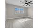 Bright bedroom with light gray wood floors, a modern ceiling fan, and a large window at 8232 Ocean Terrace Way, Las Vegas, NV 89128