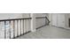 Bright hallway featuring light gray wood floors, a black metal railing, and white doors at 8232 Ocean Terrace Way, Las Vegas, NV 89128