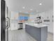 Modern kitchen featuring white cabinets, stainless steel appliances, and a gray island with marble countertops at 8232 Ocean Terrace Way, Las Vegas, NV 89128