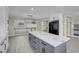 This modern kitchen features an island with marble countertop, grey cabinets, and an open floorplan at 8232 Ocean Terrace Way, Las Vegas, NV 89128
