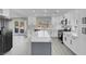Modern kitchen with white cabinets, stainless steel appliances, a gray kitchen island, and access to the backyard at 8232 Ocean Terrace Way, Las Vegas, NV 89128