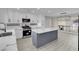 Modern kitchen features white cabinets, stainless steel appliances, and a gray kitchen island with marble countertops at 8232 Ocean Terrace Way, Las Vegas, NV 89128