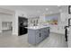 This modern kitchen features an island, white cabinets, a black refrigerator, and a view of a sunlit backyard at 8232 Ocean Terrace Way, Las Vegas, NV 89128