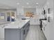 Bright kitchen features white cabinets, an island with gray base, white marble countertop, and stainless steel appliances at 8232 Ocean Terrace Way, Las Vegas, NV 89128