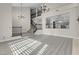 Two-story living room with light gray floors and stairs, an open kitchen view, and natural light at 8232 Ocean Terrace Way, Las Vegas, NV 89128