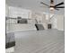 Spacious living room featuring gray wood floors and a modern ceiling fan at 8232 Ocean Terrace Way, Las Vegas, NV 89128