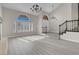 Living room with tall vaulted ceilings, large windows with shutters, and light gray floors leading up to the stairs at 8232 Ocean Terrace Way, Las Vegas, NV 89128