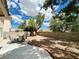 Expansive backyard featuring a concrete patio, mature trees, and low-maintenance desert landscaping at 8753 Fountain Island Dr, Las Vegas, NV 89147