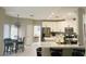 Open kitchen with white cabinetry, stainless steel appliances, island with seating, and a dining area at 8753 Fountain Island Dr, Las Vegas, NV 89147
