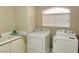 Bright laundry room features a window for natural light and a modern washer and dryer at 8753 Fountain Island Dr, Las Vegas, NV 89147