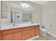 Bathroom featuring dual sinks, wood cabinets, and a separate shower with glass doors at 9009 Ochoa St, Las Vegas, NV 89143