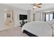 Spacious bedroom with neutral colored walls and carpet, TV and ensuite bath at 9009 Ochoa St, Las Vegas, NV 89143